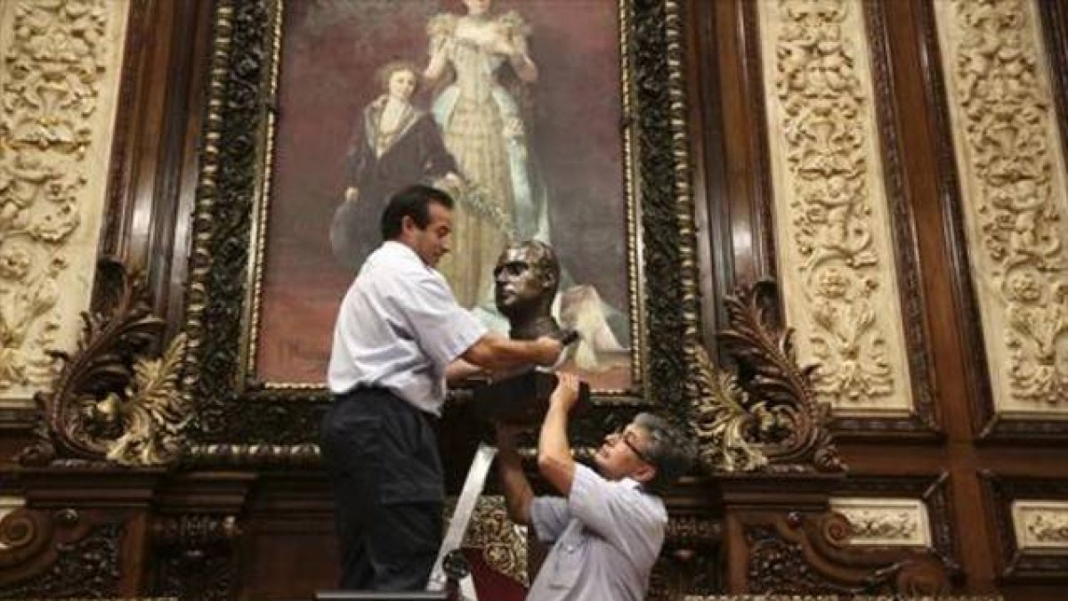 Operarios del Ayuntamiento de Barcelona retiran el busto del rey Juan Carlos del salón de plenos municipal antes de guardarlo en una caja de cartón.-Foto: DANNY CAMINAL / CARLA FAJARDO