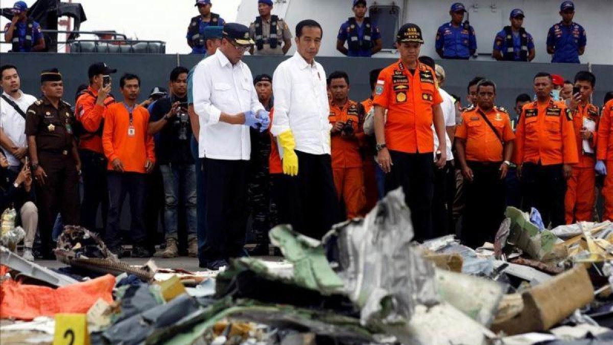 El presidente indonesio, Joko Widodo (centro), inspecciona algunos de los restos del avión de Lion Air siniestrado.-EDGAR SU (REUTERS)