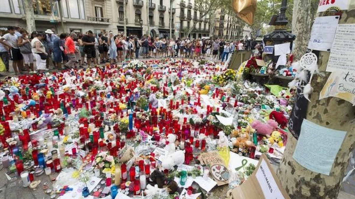Muestras de afecto y solidaridad junto a la fuente de canaletas en las Ramblas tras los atentados.-JORDI COTRINA