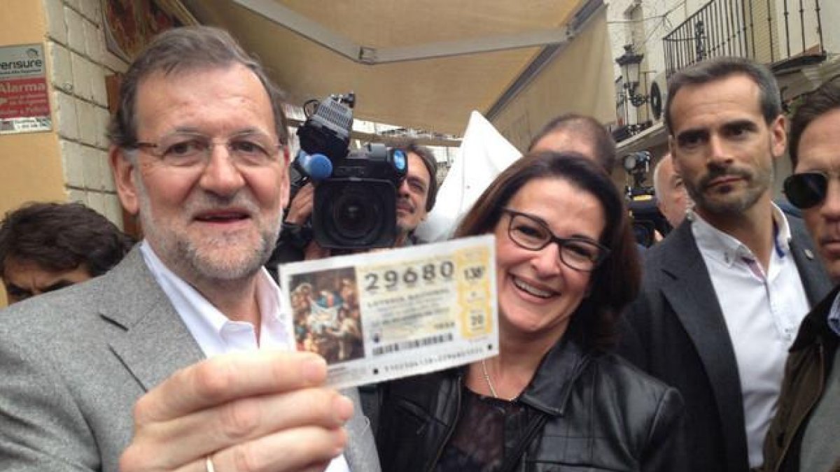 Mariano Rajoy recibe un décimo de lotería durante su recorrido por Estepona (Málaga).-