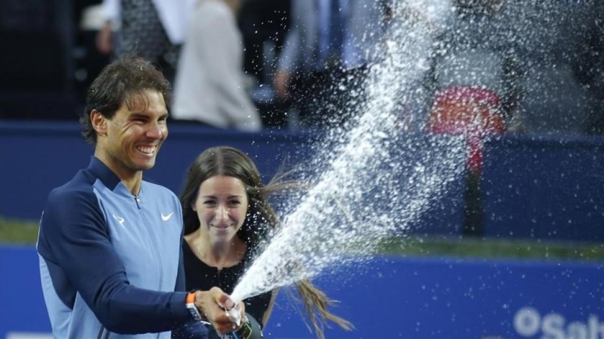 Nadal rocía con cava la pista del RCT Barcelona tras su victoria del domingo-MANU FERNÁNDEZ / AP