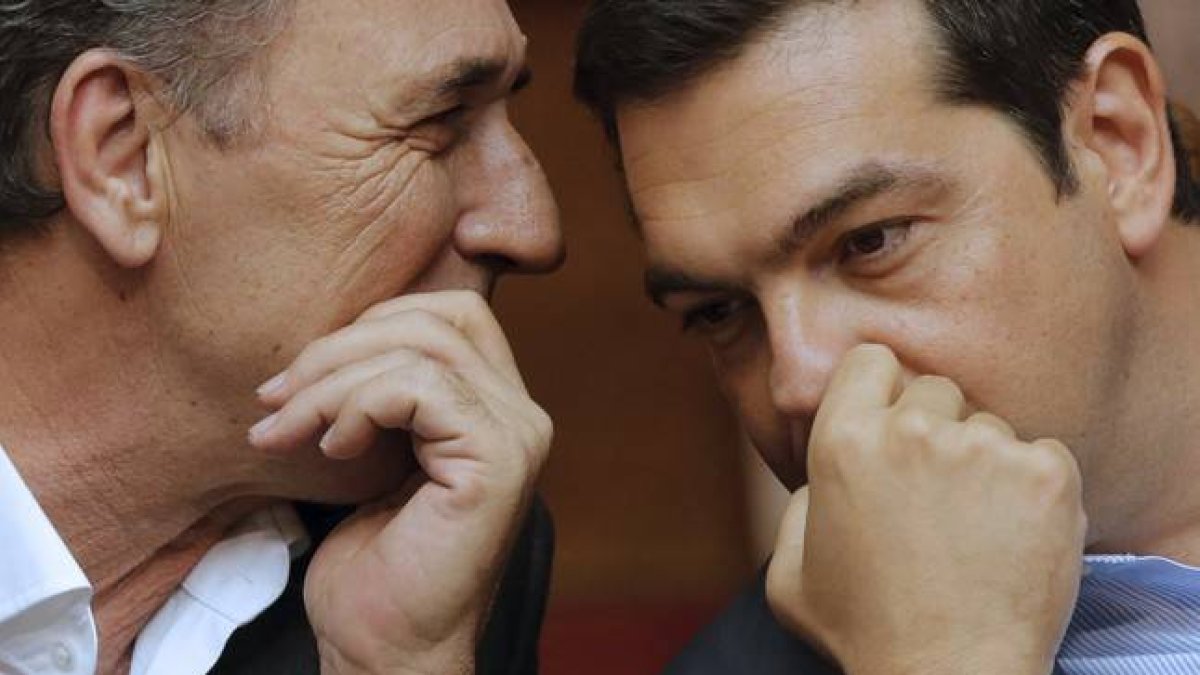 El primer ministro griego, Alexis Tsipras, habla con su titular de Economía, Giorgos Stathakis, este viernes en el Parlamento.-REUTERS / CHRISTIAN HARTMANN