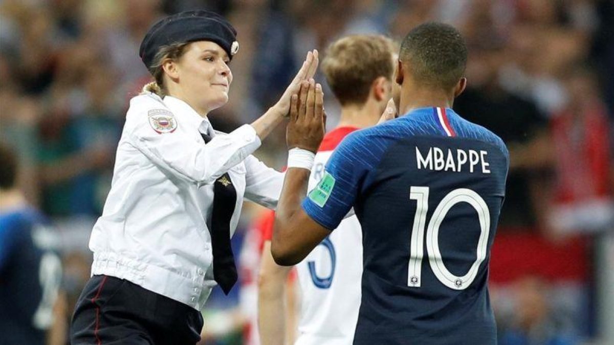 Una miembro de la banda Pussy Riot chocandole la mano a Kylian Mbappé.-DARREN STAPLES