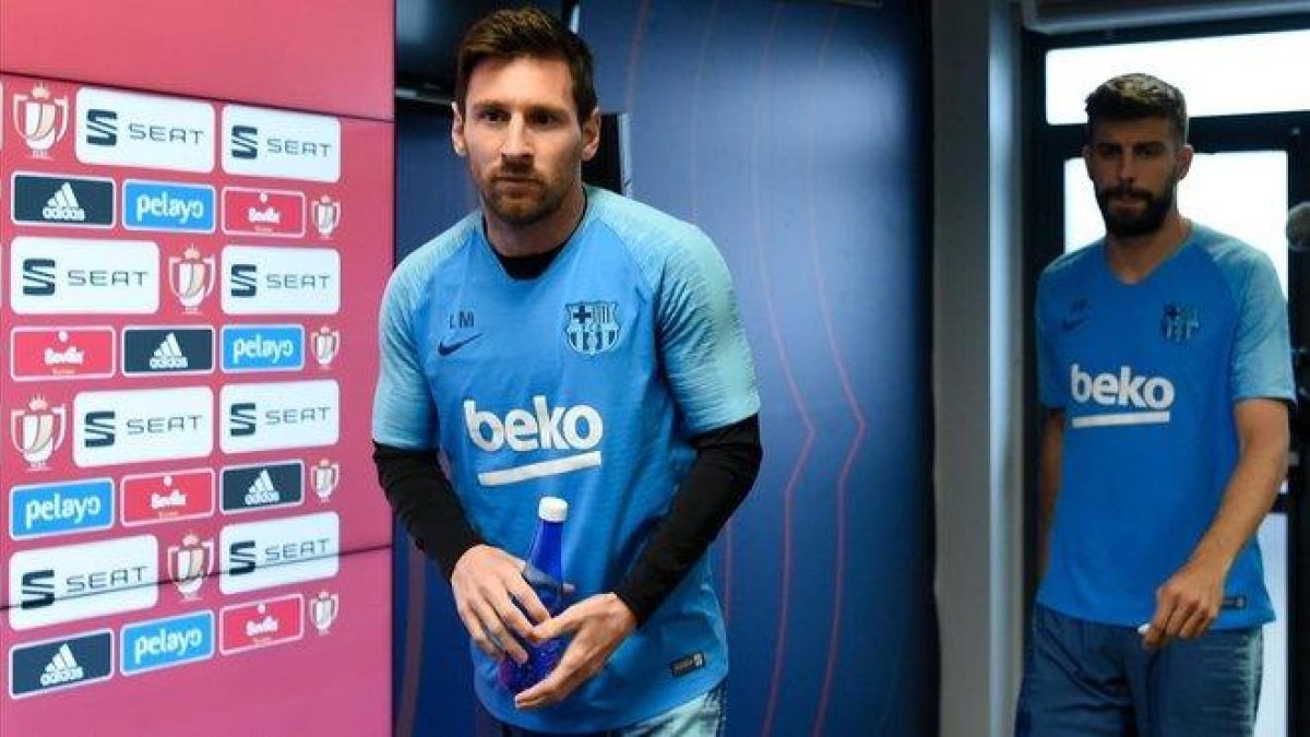 Messi entra en la sala de prensa de la ciudad deportiva de Sant Joan Despí junto a Piqué.-AFP / JOSEP LAGO
