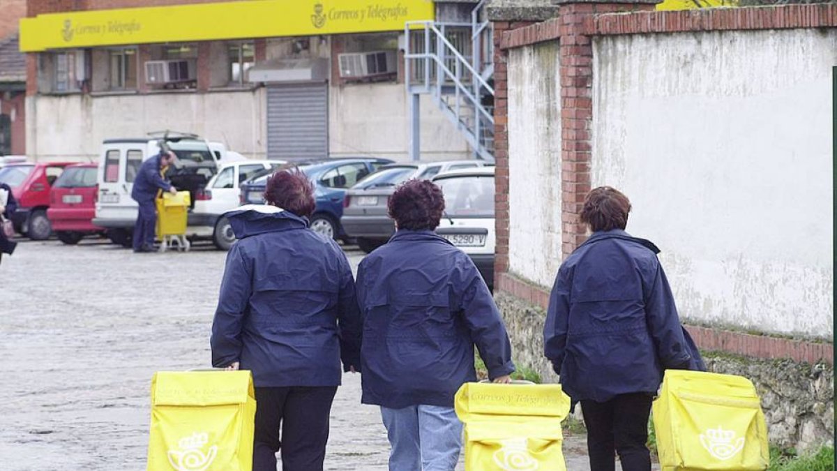 Tres trabajadoras de correos entrando con sus carros a las instalaciones de la entidad en la capital.-ISRAEL L. MURILLO