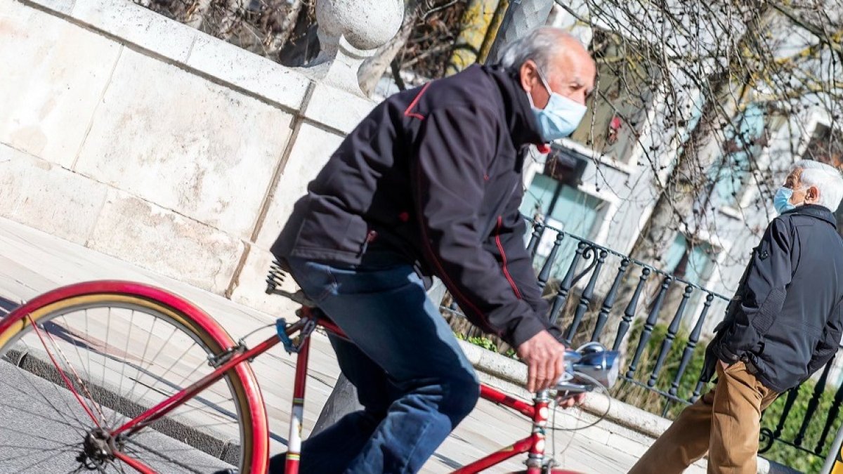 Un hombre circula en bicicleta por el centro de Burgos. SANTI OTERO