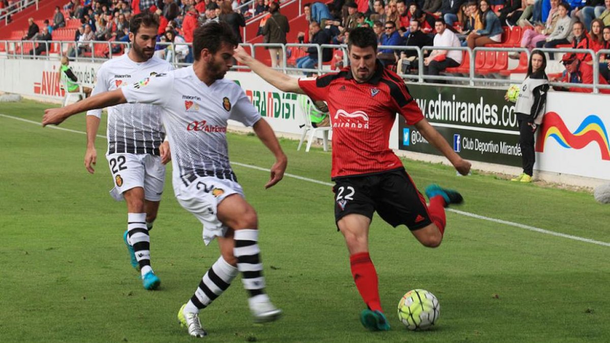 Álex García se dispone a golpear un esférico ante la oposición de un jugador del RCD Mallorca en el choque de ayer en Anduva-Alfonso G. Mardones