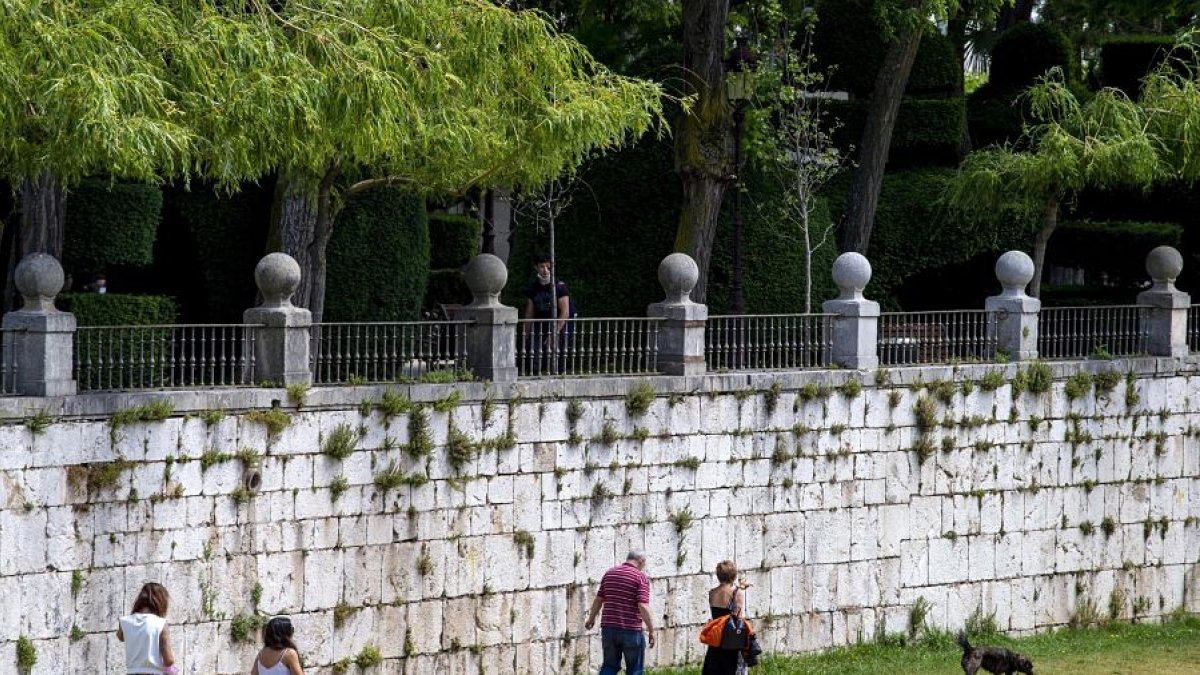 Varias personas pasean con sus perros por la orilla del río Arlanzó en el centro de la ciudad de Burgos. SANTI OTERO