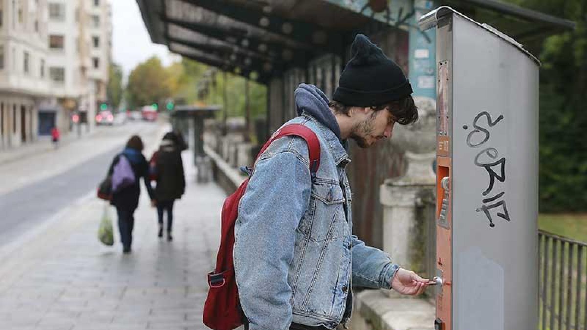 Un joven recarga su tarjeta de autobús en la parada de la avenida Arlanzón.-RAÚL G. OCHOA