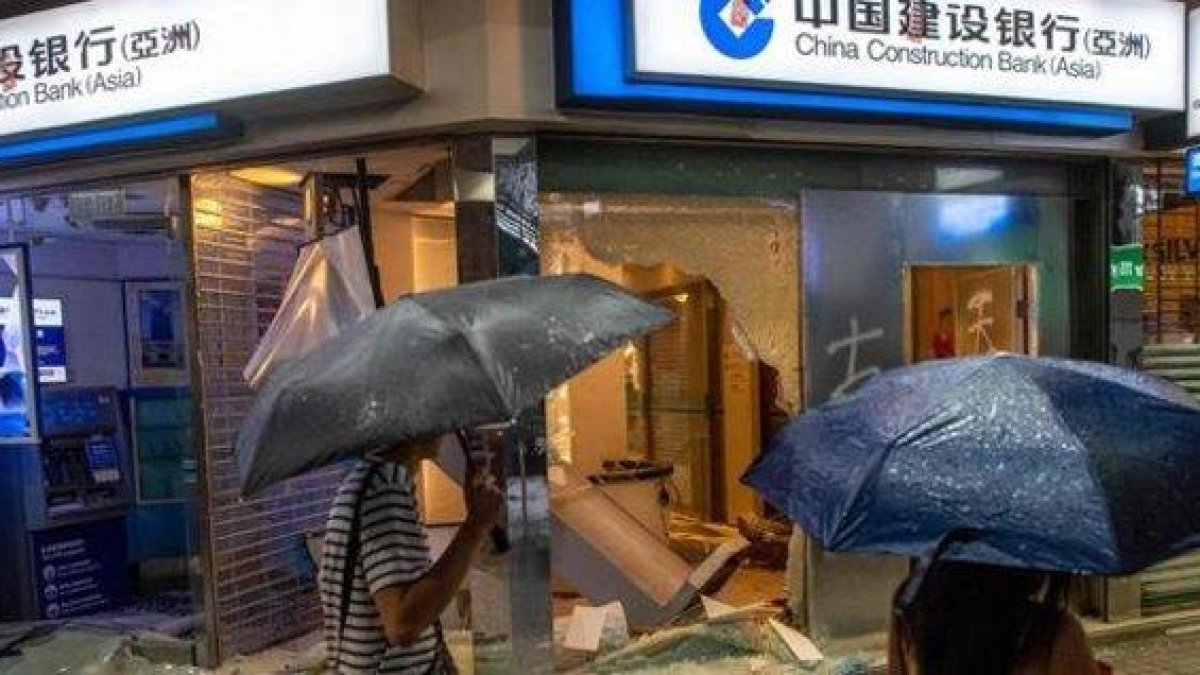 Vandalismo contra un banco de China en Hong Kong.-NICOLAS ASFOURI (AFP)