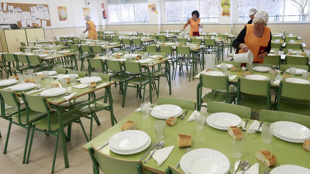 Varias monitoras de comedor preparan las mesas en un colegio. RAÚL G. OCHOA