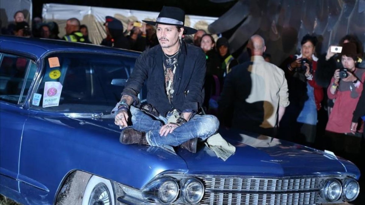 El actor estadounidense Johnny Depp, posando sobre un coche, esta noche en el festival de Glastonbury, en Inglaterra.-EFE / NIGEL RODDIS