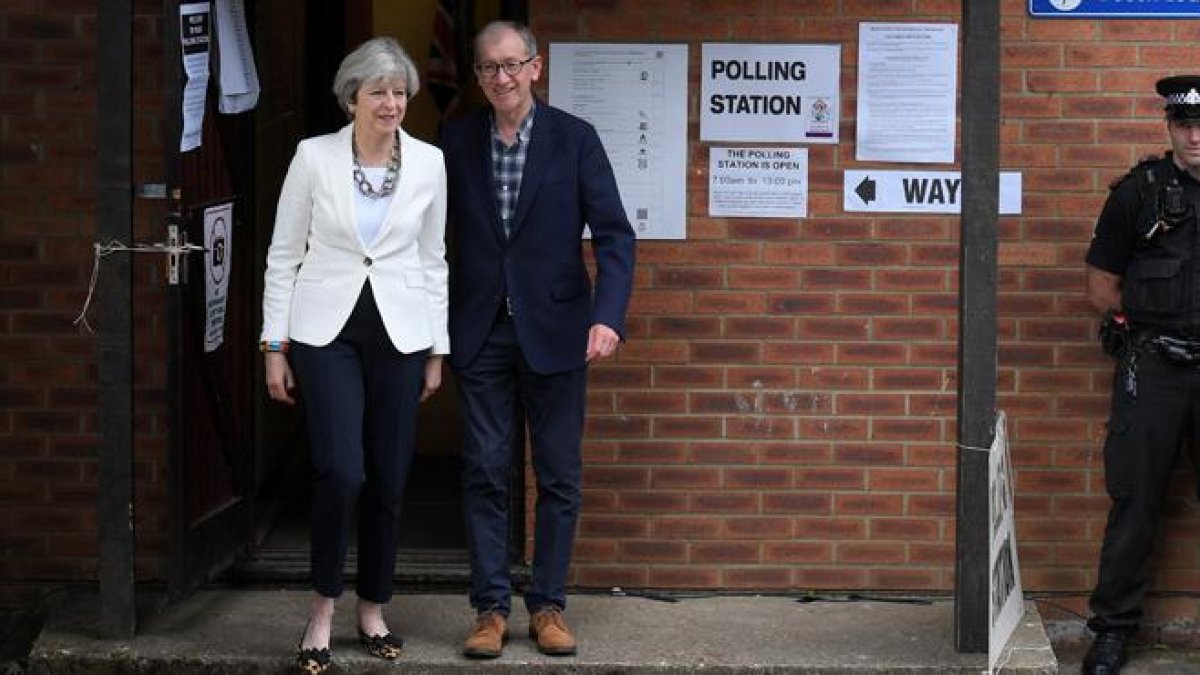 Theresa May sale del colegio electoral tras ejercer su derecho a voto.-