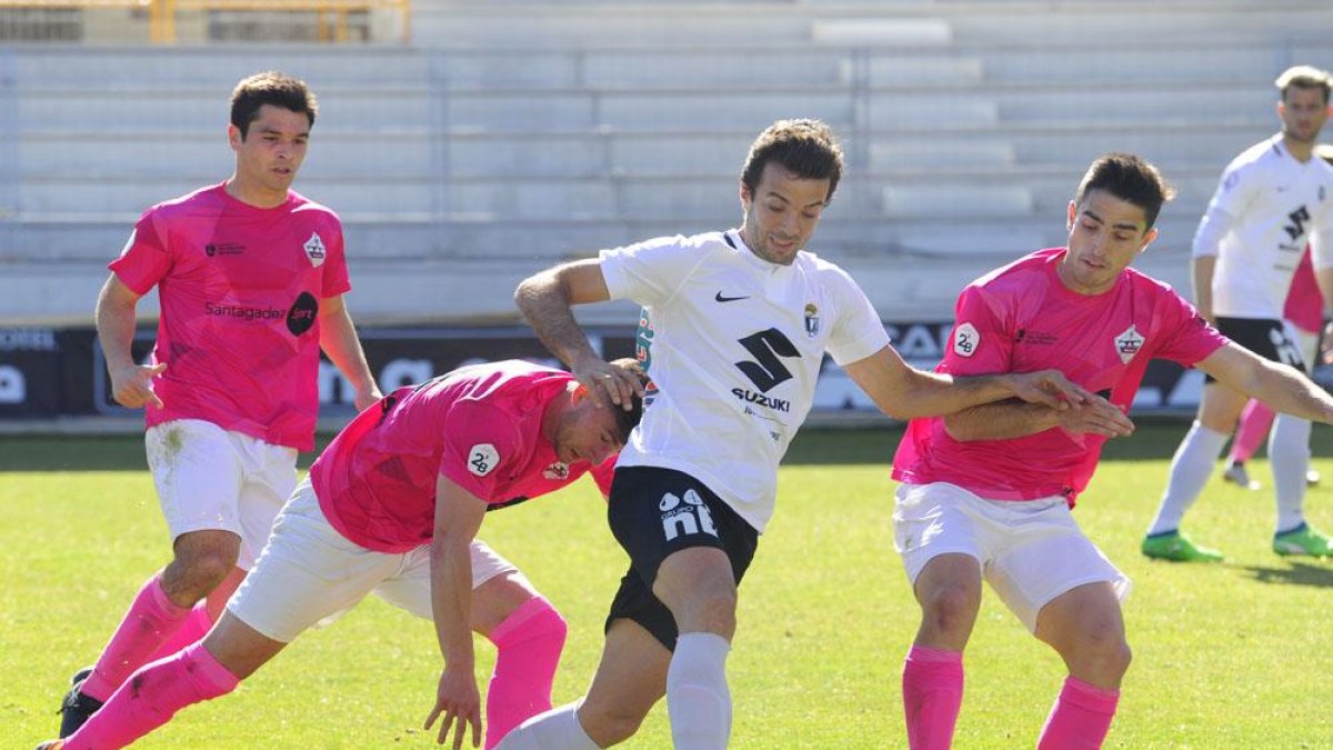 Fer Ruiz, que volvió a ser titular, conduce el balón entre dos jugadores del UD Sanse.-ISRAEL L. MURILLO