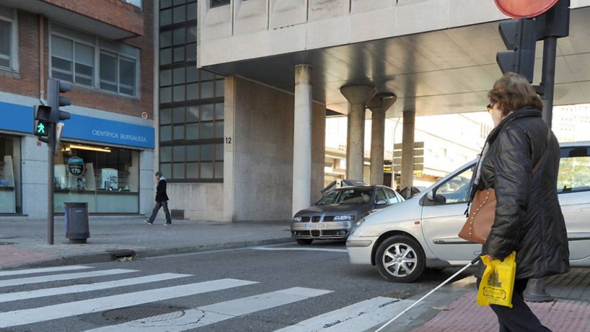 Una mujer invidente cruza un paso de peatones de la ciudad.-Israel L. Murillo