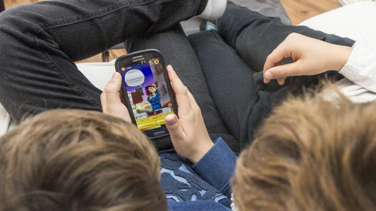 Dos niños jugan a un videojuego a través del móvil.-ISRAEL L. MURILLO