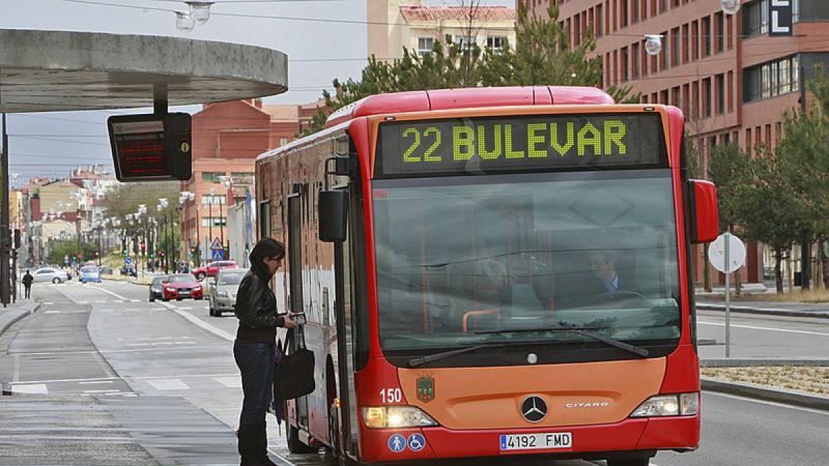 Una mujer se dispone a subir a un autobús municipal.