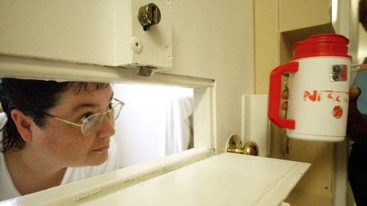 Kelly Gissendaner mira por la rendija de la puerta de su celda, en julio del 2004.-AP / BITA HONARVAR
