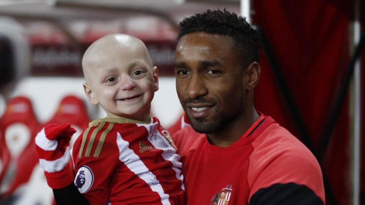 Jermain Defoe, delantero del Sunderland, sostiene en brazos a Bradley Lowery.-REUTERS