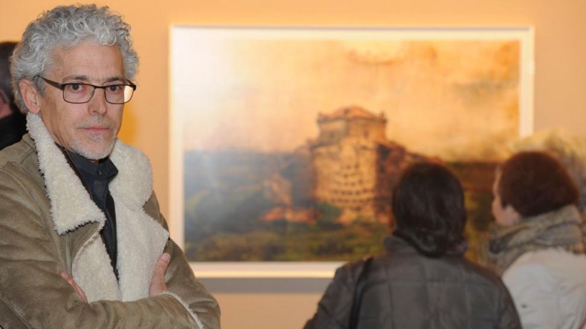 Santiago Alonso Sagredo posa en primer plano mientras unas señoras observan una fotografía de Castroverde de Campos (Zamora).-Israel L. Murillo