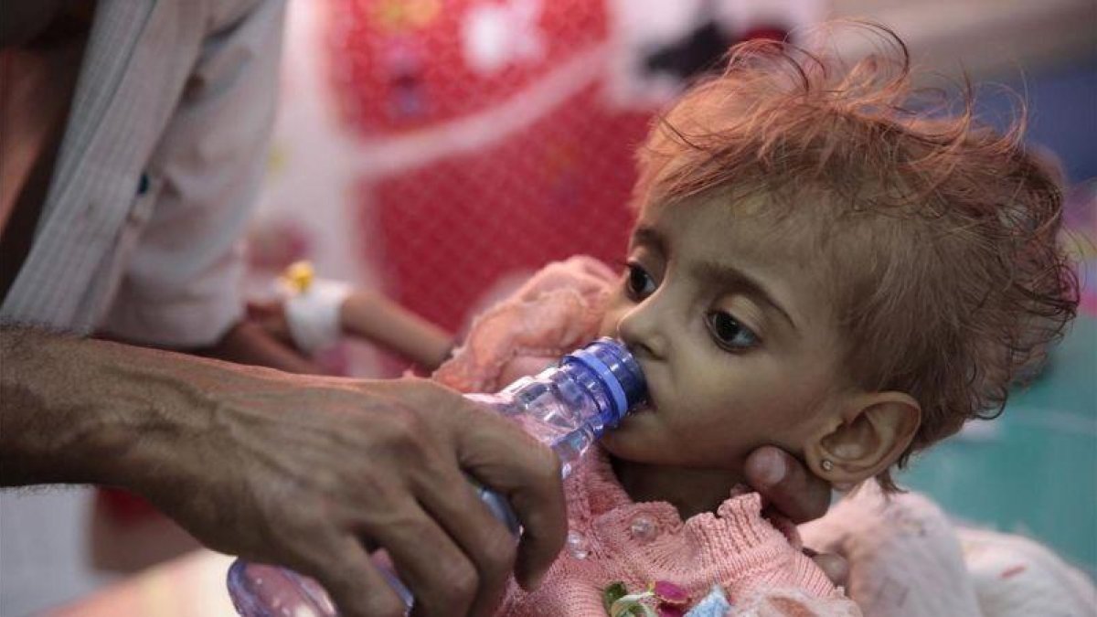 Un padre da de beber a su hija desnutrida el pasado mes de septiembre en un centro hospitalario de Hodeida, ciudad bombardeada por Arabia Saudí y sus aliados.-AP / HANI MOHAMMED
