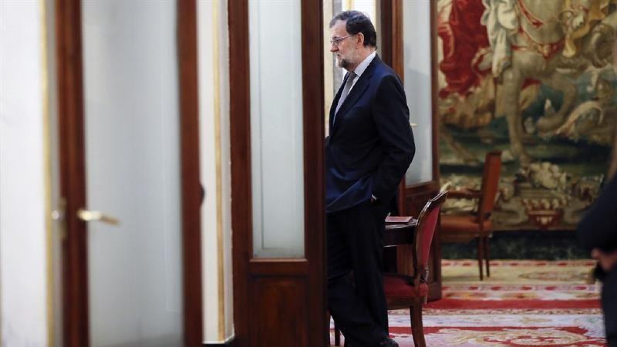El presidente del Gobierno, Mariano Rajoy, en los pasillos del Congreso de los Diputados donde hoy tiene la lugar la primera sesión de control al Gobierno de 2017.-EFE