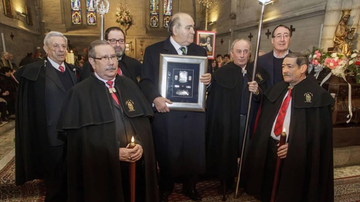Juarranz, arriba a la derecha, junto a otros cofrades de San Antón tras la misa dedicada a la Virgen de Las Candelas en la Antigua entregan a José María Peña, exalcalde de Burgos, el premio de Tito de Oro 2015.-SANTI OTERO