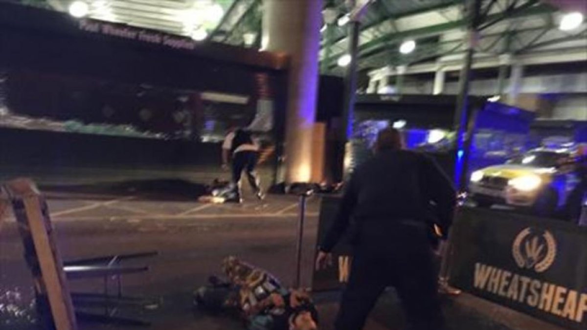 Los tres sospechosos del ataque yacen en el suelo tras ser tiroteados por la policía, ayer, en Londres.-AP / GABRIELE SCIOTTO