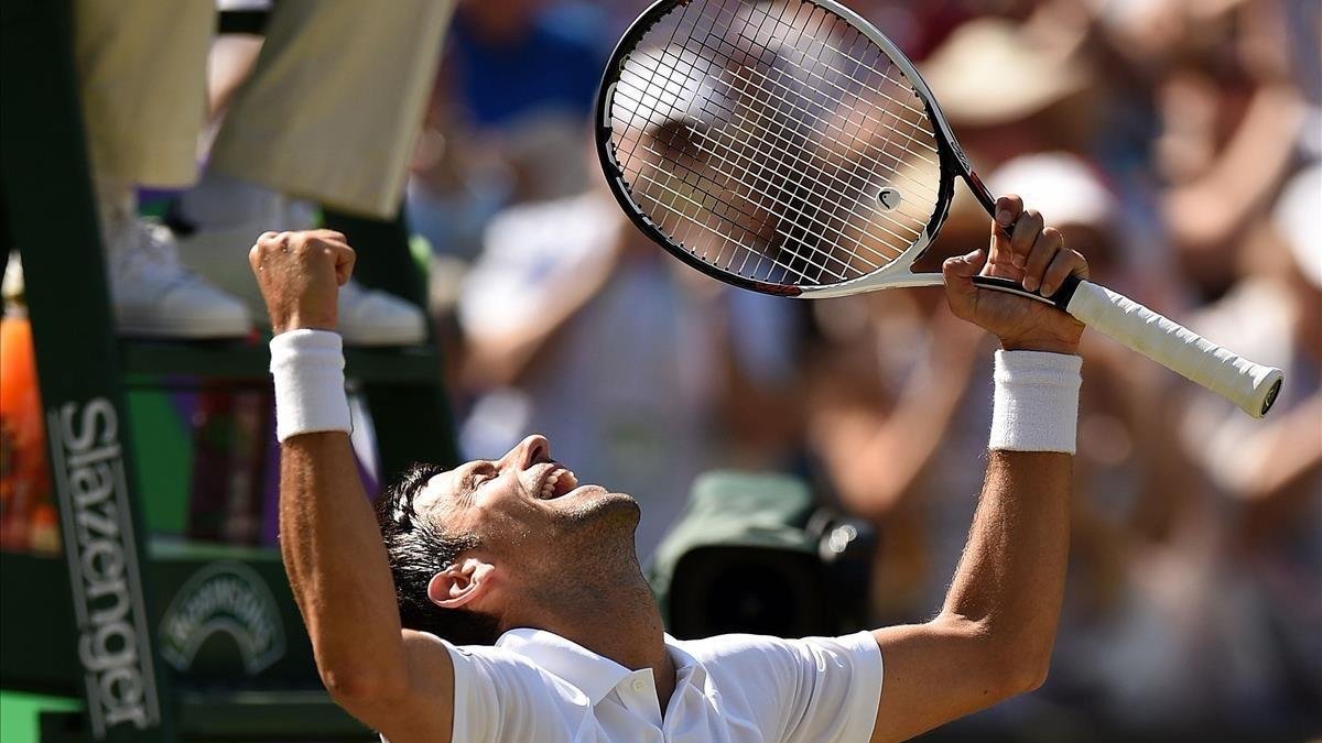 Djokovic celebra, a pie de pista, su triunfo en Wimbledon /-OLI SCARFF (AFP)