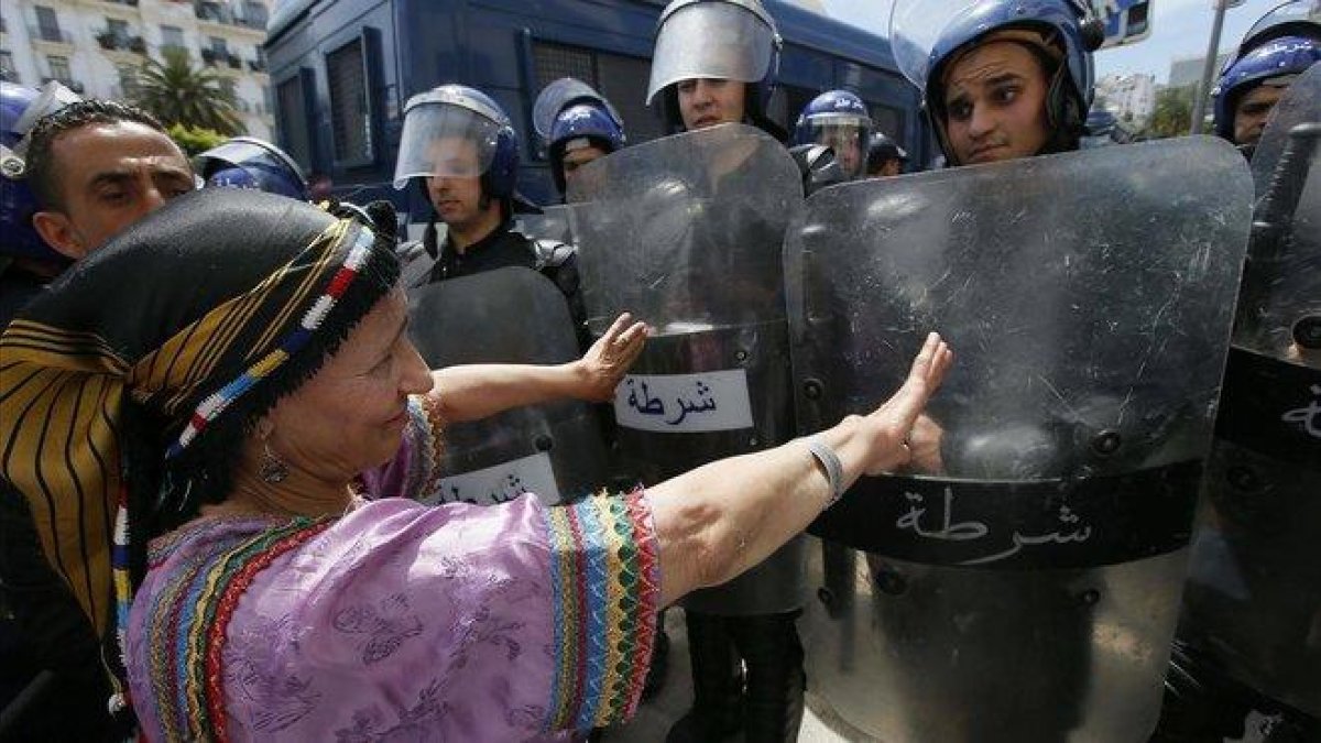 Una mujer protesta frente a la policía en Argel (Argelia).-ANIS BELGHOUL (AP)