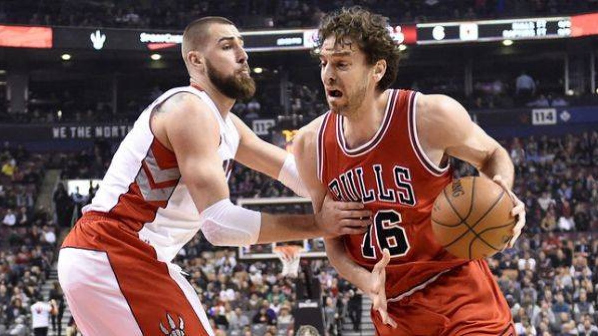 Pau Gasol trata de avanzar con el balón ante la férrea defensa de Jonas Valanciunas, en el partido entre los Bulls y los Raptors.-Foto: AP / FRANK GUNN