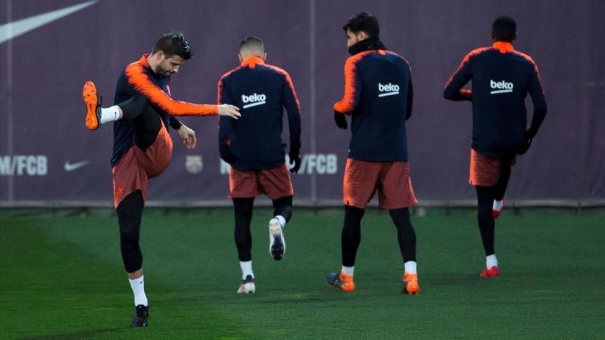 Piqué, en el último entrenamiento del Barça antes de viajar a Mestalla para la Copa.-EFE / ENRIC FONTCUBERTA