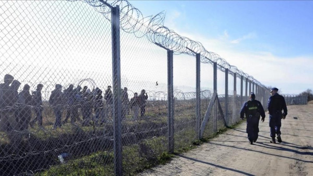 Un grupo de refugiados pasa por la valla que separa a Hungría de Serbia.-AP / ZOLTAN GERGELY KELEMER
