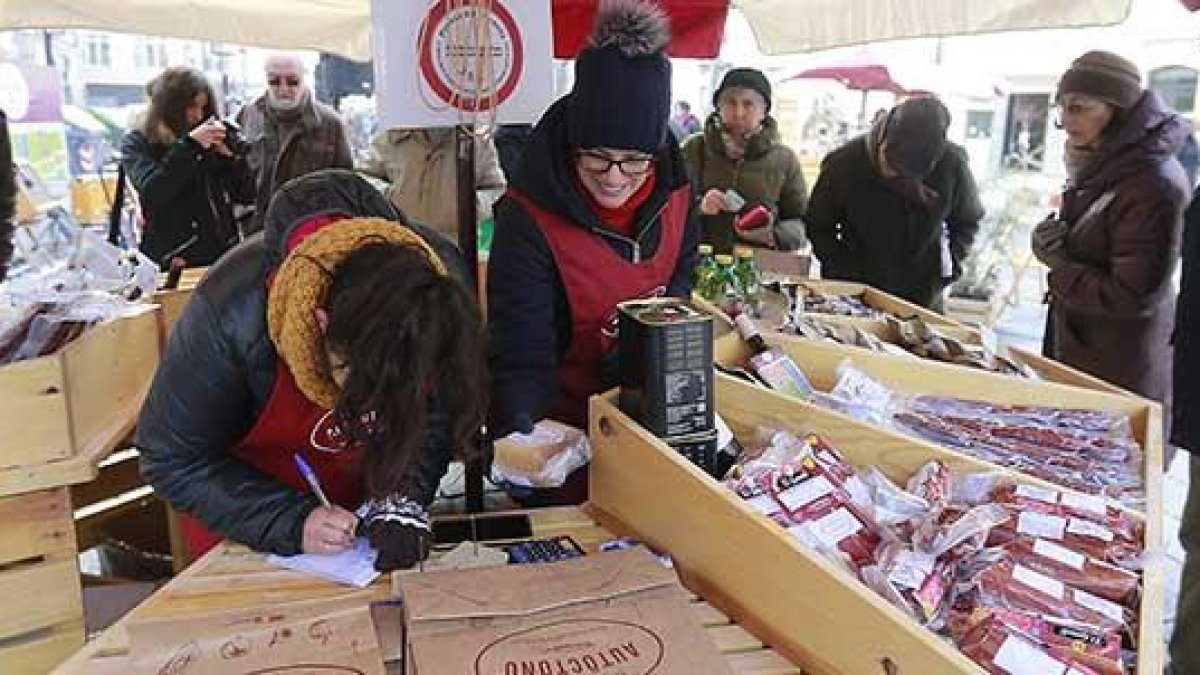 Dos miembros de Fundación Oxígeno atienden uno de los puestos del mercado ubicado en la Plaza de La Flora.-RAÚL G. OCHOA