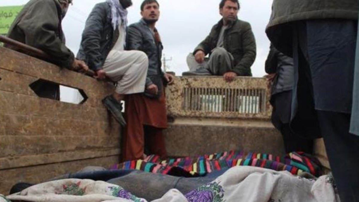 Un grupo de afganos trasladan los cuerpos de las 13 víctimas civiles asesinadas en Kunduz.-EFE