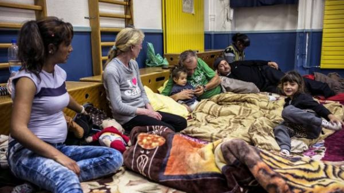 Una familia en el gimnasio de una de las escuelas ocupadas en Lyon.-Foto: AFP / JEFF PACHOUD