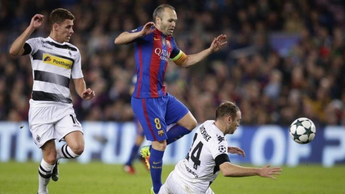 Iniesta evita a Jantschke, el jugador del Borussia, en el Camp Nou.-AP / MANU FERNÁNDEZ