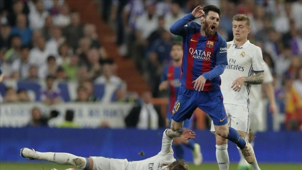 Sergio Ramos, en el suelo delante de Messi, en el clásico del pasado mes de abril.-AP / DANIEL OCHOA DE OLZA