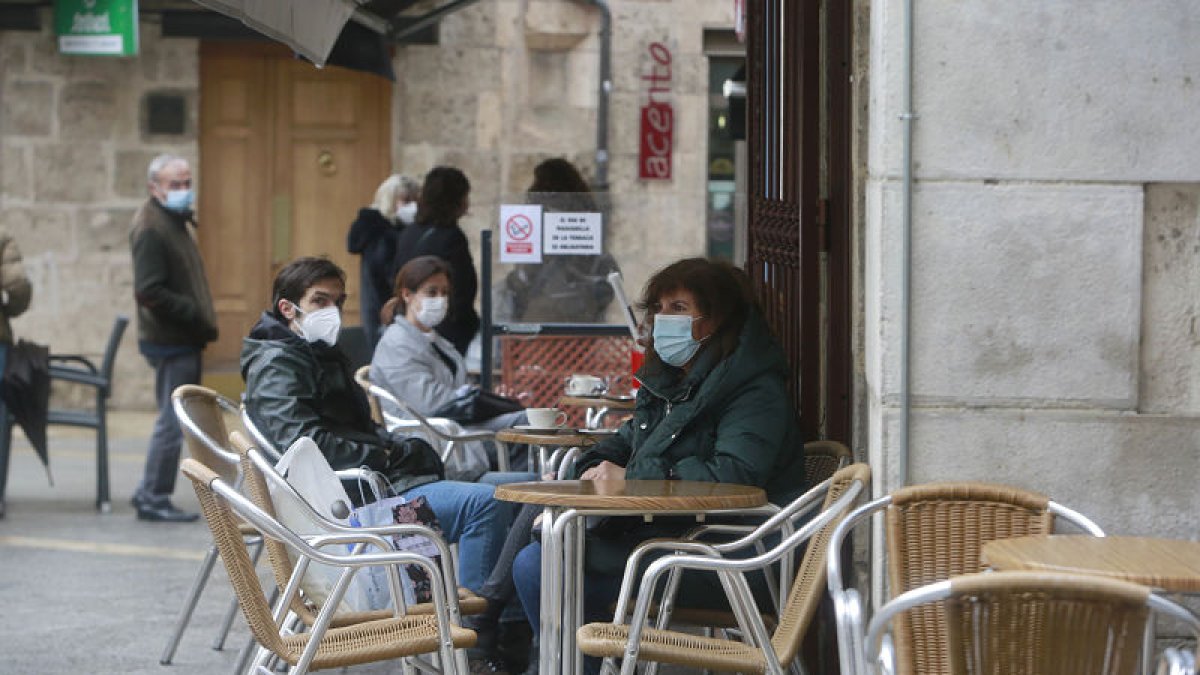 Unas personas sentadas en una terraza recientemente abierta.