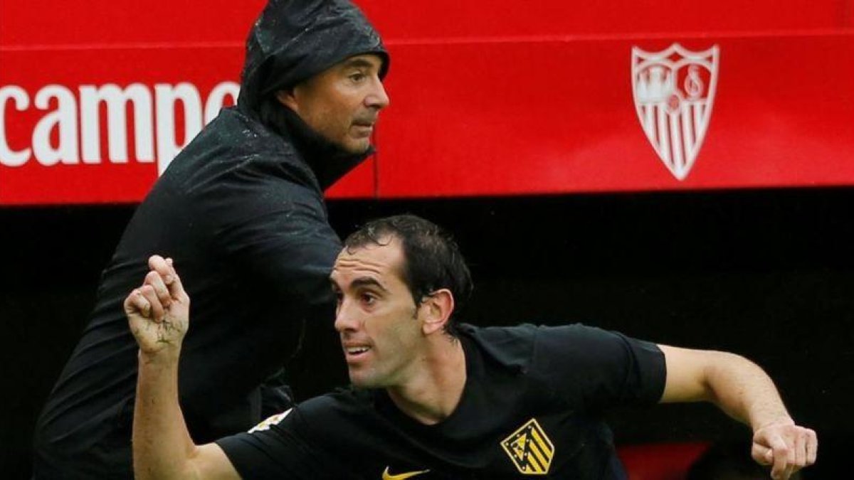 Sampaoli, detrás de Godín, en el partido del pasado domingo en el que el Sevilla derrotó al Atlético.-MARCELO DEL POZO