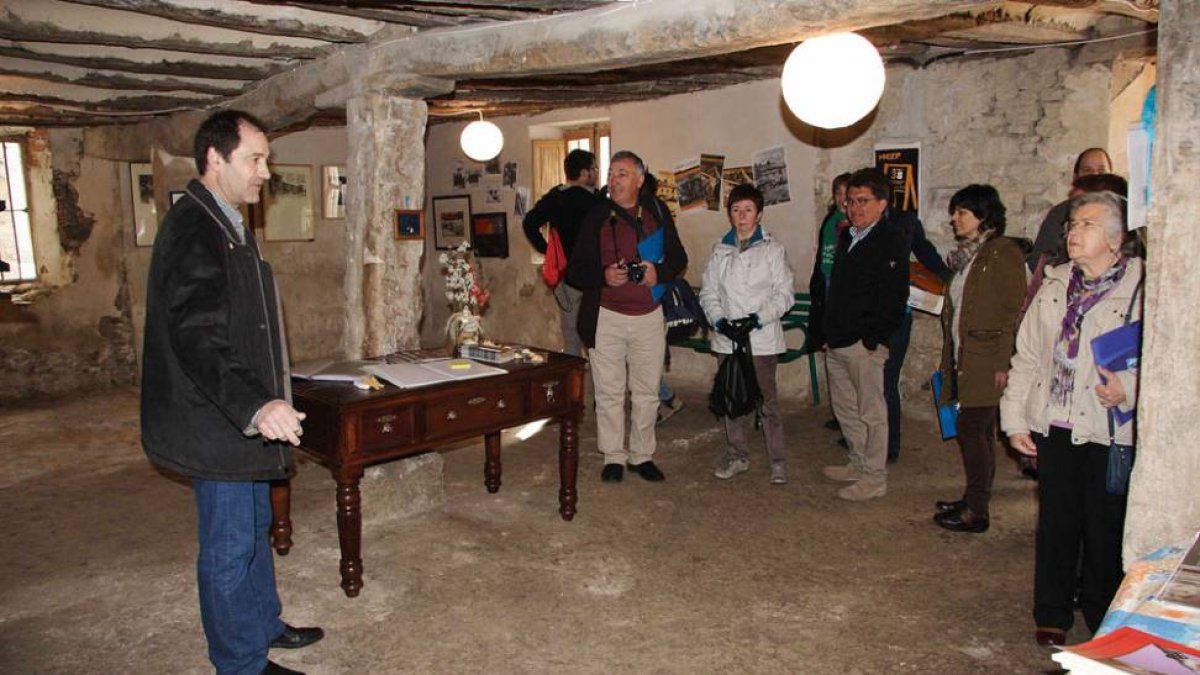 El alcalde de Bañuelos de Bureba, Jesús Viadas, explica a los asistentes las obras realizadas hasta el momento en la antigua escuela.-G.G.