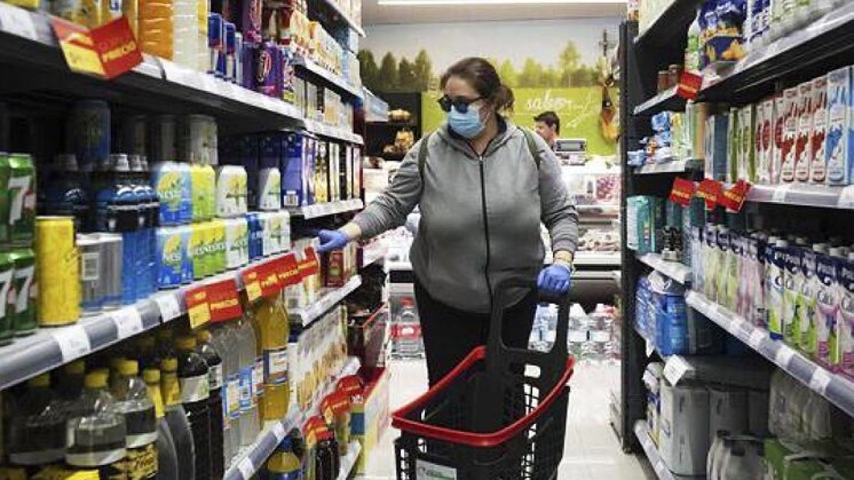 Una mujer con mascarilla, en un supermercado. EL MUNDO