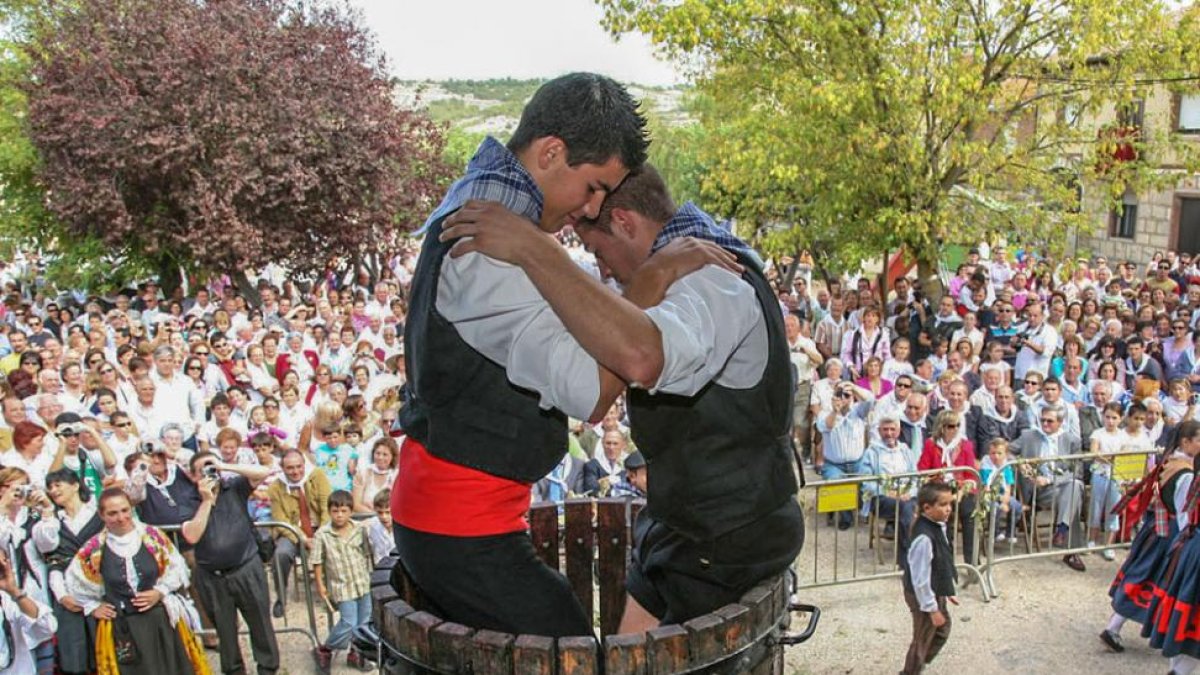 Dos jóvenes pisan la uva durante la Fiesta de la Vendimia de la Denominación de Origen Arlanza.-ECB