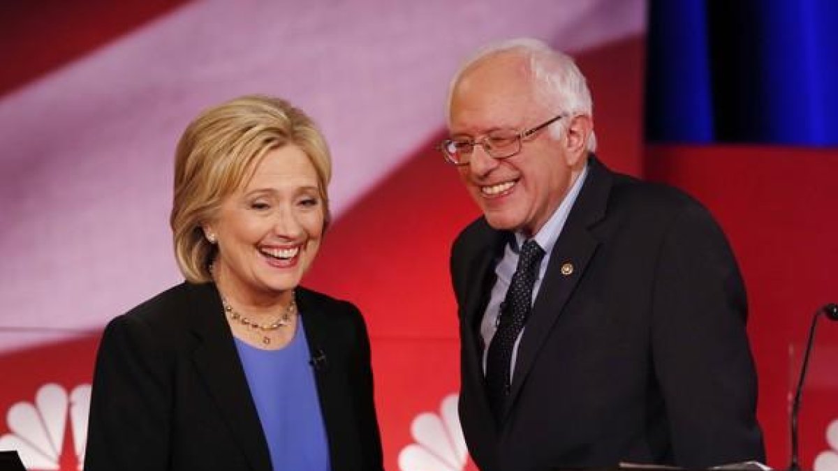 Hillary Clinton y Bernie Sanders sonríen durante una pausa del debate de candidatos demócratas, el domingo en Charleston.-AP / MIC SMITH