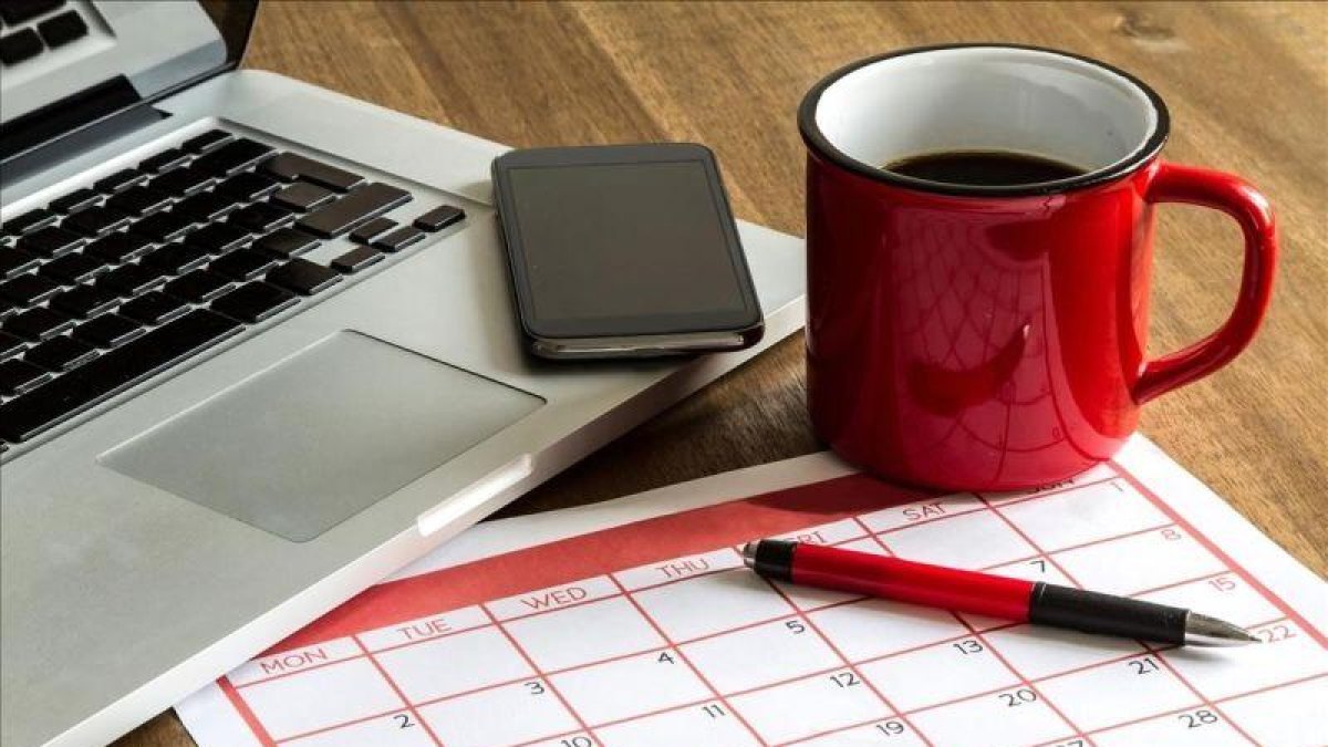 Ordenador portátil y calendario mensual.-123RF