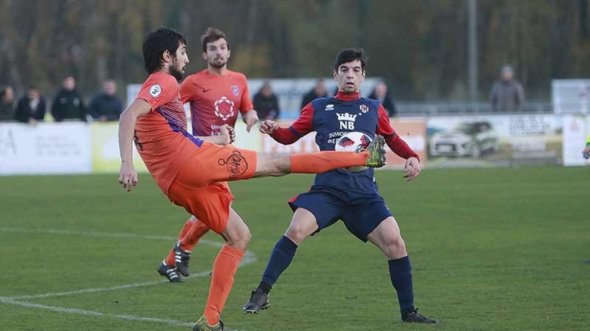 Óscar Vázquez golpea un balón en presencia de jugador del Atlético Bembibre-Raúl G. Ochoa