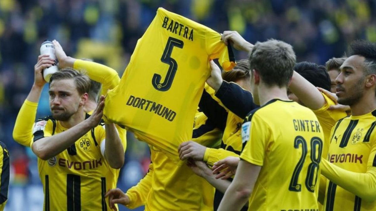 Los jugadores del Dortmund muestran una camiseta de Bartra mientras celebran el triunfo ante el Eintracht de Fráncfort, este sábado en Iduna Park.-RALPH ORLOWSKI