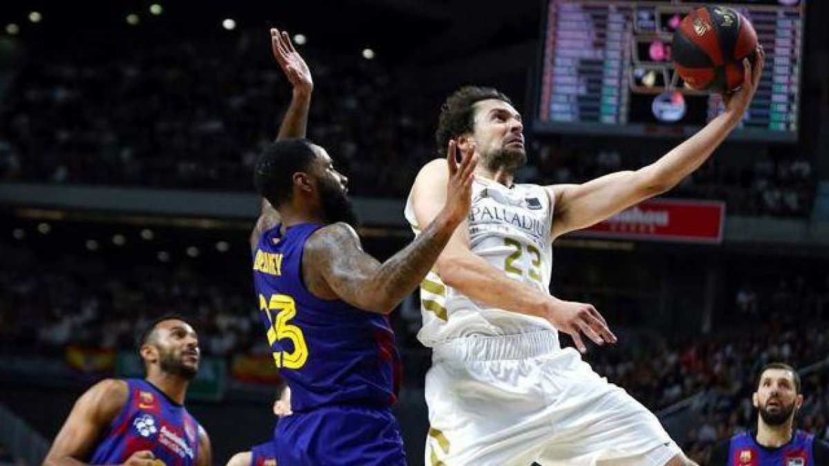 Serbgio Llull entra a canasta defendido por Malcolm Delamey.-EFE / EMILIO NARANJO