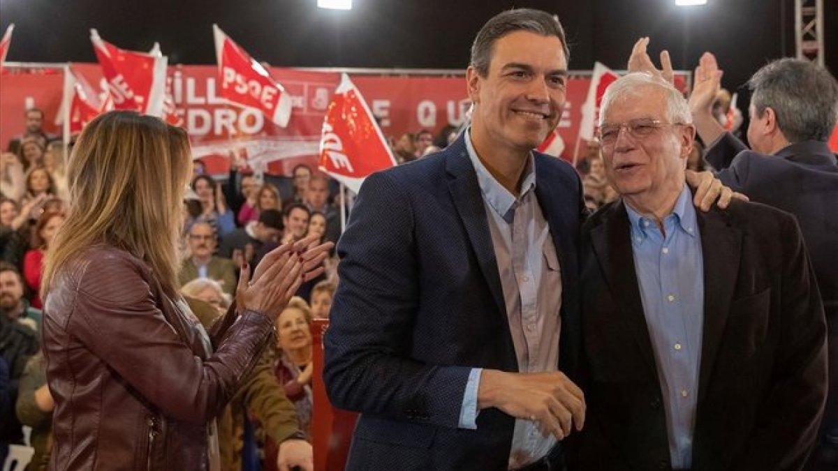 El presidente del Gobierno, Pedro Sánchez, saluda al ministro de Exteriores, Josep Borrell durante el mitin que han celebrado en Sevilla. A la izquierda, Susana Díaz, secretaria general de los socialistas andaluces.-JULIO MUÑOZ (EFE)