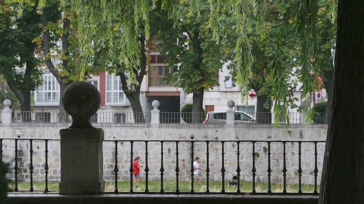 Dos personas pasean por las riberas del Arlanzón, en una imagen tomada desde el Paseo del Espolón.-RAÚL G. OCHOA
